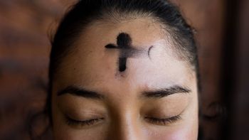 Christin trägt Aschekreuz auf der Stirn